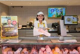 Mitarbeiter in der Feinkostabteilung beraten Kunden.