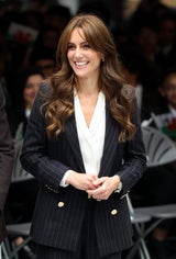 Kate Middleton kombiniert ihren Nadelstreifen-Anzug mit dezentem Schmuck und einer weißen Bluse.