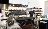 An seinem Schreibtisch wird gezeichnet und an den verschiedenen Nähmaschinen gewerkt.