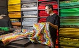 In meterhohen Regalen liegen Tausende Meter Stoff fein säuberlich nach Farben und Texturen sortiert.