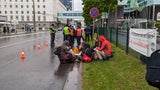 Klima-Aktivisten ketten sich mit Metallrohren aneinander fest