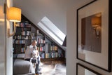 Dem Schlafzimmer verleiht ein meterhohes Bücherregal Gemütlichkeit.  