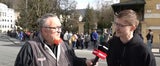 oe24.TV-Reporter Mike Vogl in Salzburg - im Hintergrund lange Warteschlange.