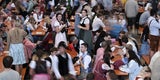 Die ersten Wiesn-Besucher 2023 nehmen in einem Festzelt Platz.