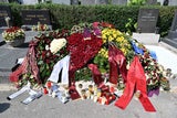 Richard Lugners letzte Ruhestätte ist mit Kränzen übersät. Auch ein "Gemma Lugner"-Kapperl wurde hier platziert