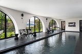 Schwimmen bei jedem Wetter: Im Innenbereich der Villa gibt es einen großen beheizten Pool mit riesigen halbrunden Fenstern.
