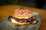 BBQ-Krapfen: frisch gebackenen Krapfen mit Ahorn-Speckglasur, Marillenmarmelade, knusprigem Bacon, einem saftigen Rindfleisch-Patty und einer extra rauchigen BBQ-Sauce.