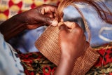 Frauen in Ruanda flechten die Taschen