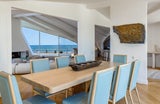 Ausreichend Platz für Familie und Gäste bietet auch der Essbereich, der direkt an das riesige Wohnzimmer mit überdimensionaler Couchlandschaft anschließt. Zartes Blau in den Stühlen schafft eine perfekte Verbindung zur Farbe des Ozeans.&nbsp;&nbsp;