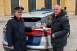 Landespolizeipräsident Gerhard Pürstl und Innenminister Gerhard Karner präsentieren QR-Codes für Jobinteressierte auf den Heckscheiben der Polizei-Autos.