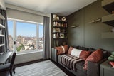 Die Wohnung ist ein gemütliches Refugium im hektischen New York. Im Arbeitszimmer gibt es genug Stauraum für Bücher und Unterlagen, das Sofa macht den Raum mit Pölstern in warmem Rot.