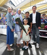 Martina Polleres-Hyll (Leiterin der Caritas-Bildungsangebote) und der Wiener Caritasdirektor Klaus Schwertner sowie eine Familie.