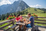 Zwieselalm. Bei der Hüttenjause genießt man den Panoramablick auf Dachstein und Gosaukamm.