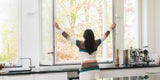 Frau an offenem Fenster