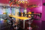 Der Tisch aus Onyx ist beleuchtet – darüber eine außergewöhnliche Designerlampe.  