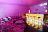 Das riesige Designer-Sofa im rund 100 Quadratmeter ­großen Wohnzimmer vor der beleuchteten Onyx-Bar.  
