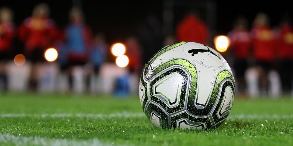 Ein Fußball auf einem grünen Rasen.