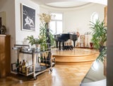 Im großen Salon befindet sich ein halbrundes Podest, auf dem ein Flügel steht, der auch selbst spielen kann. „Ein Wunsch meines Mannes“, lacht die Gastgeberin.
