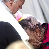 Gütiger Papst küsst Schwerkranke