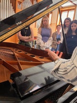 Die Teilnehmerinnen hören der Musikerin aufmerksam zu. 