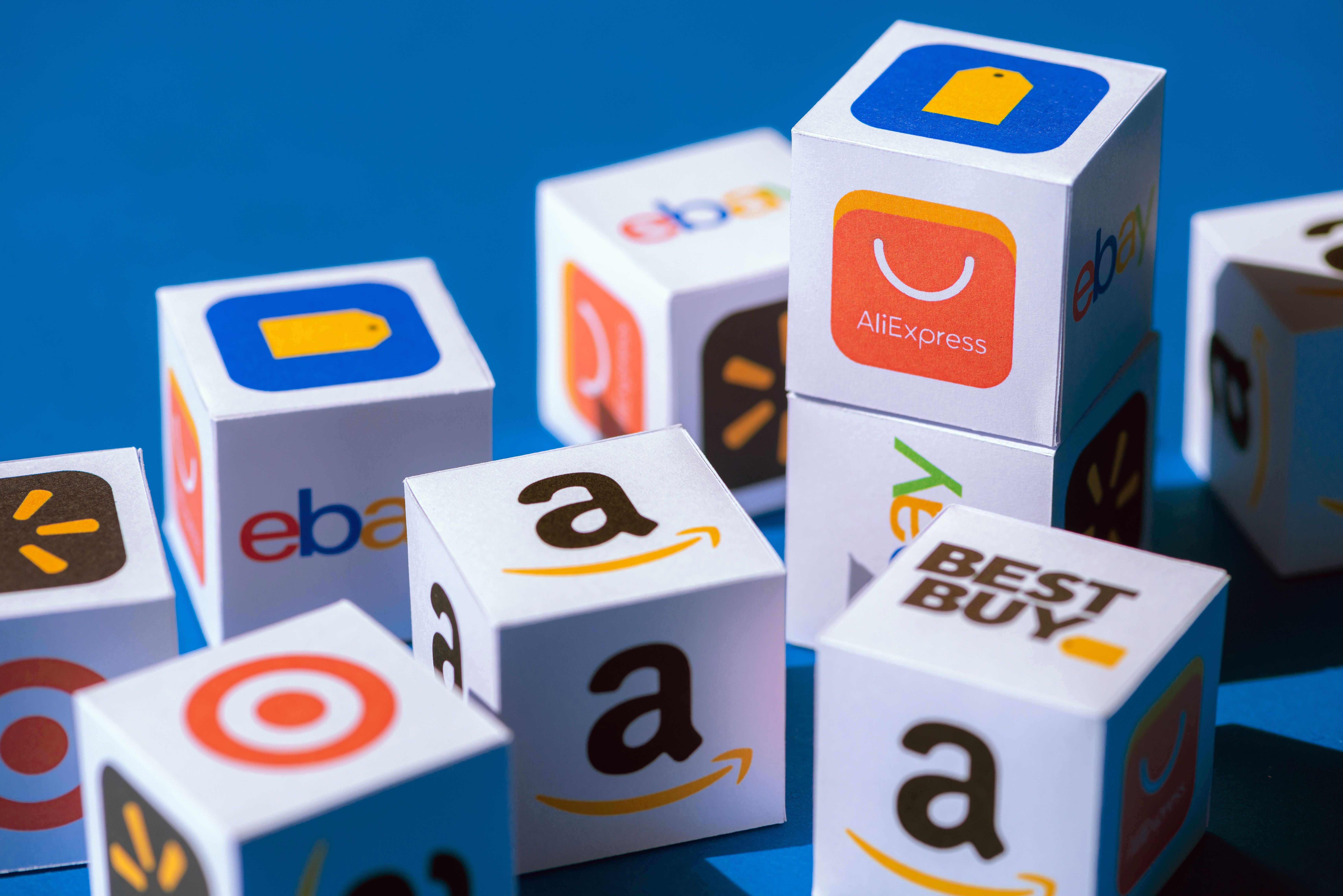 Kyiv, Ukraine - September 10, 2019: A paper cubes collection with printed logos of eCommerce corporations and online retail stores, such as AliExpress, WallMart, eBay, Amazon, and others.