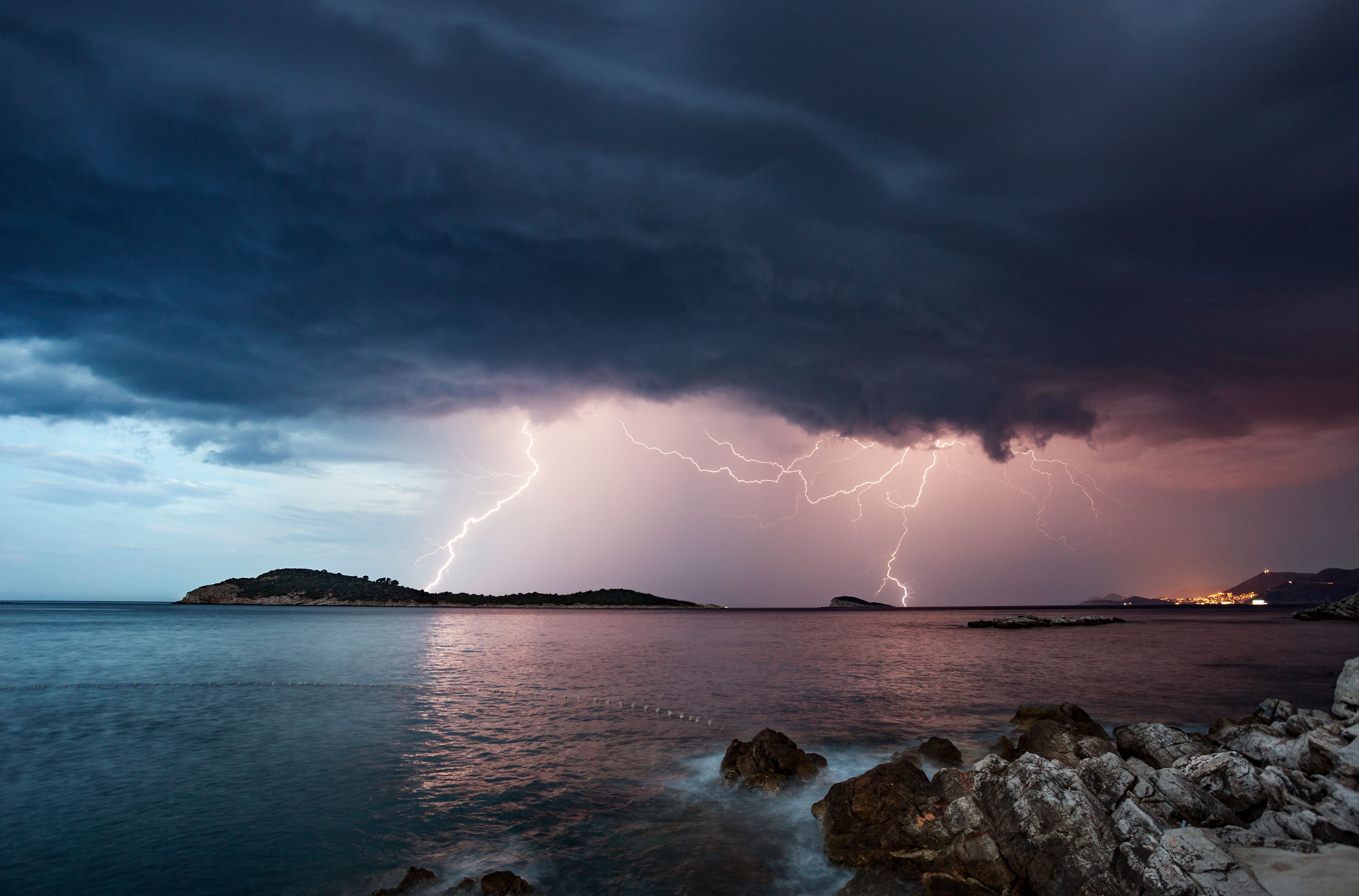 A violent thunderstorm approaching over the Adriatic Sea, with the lights of Dubrovnik Old Town visible in the distance, Dalmatia, Croatia.