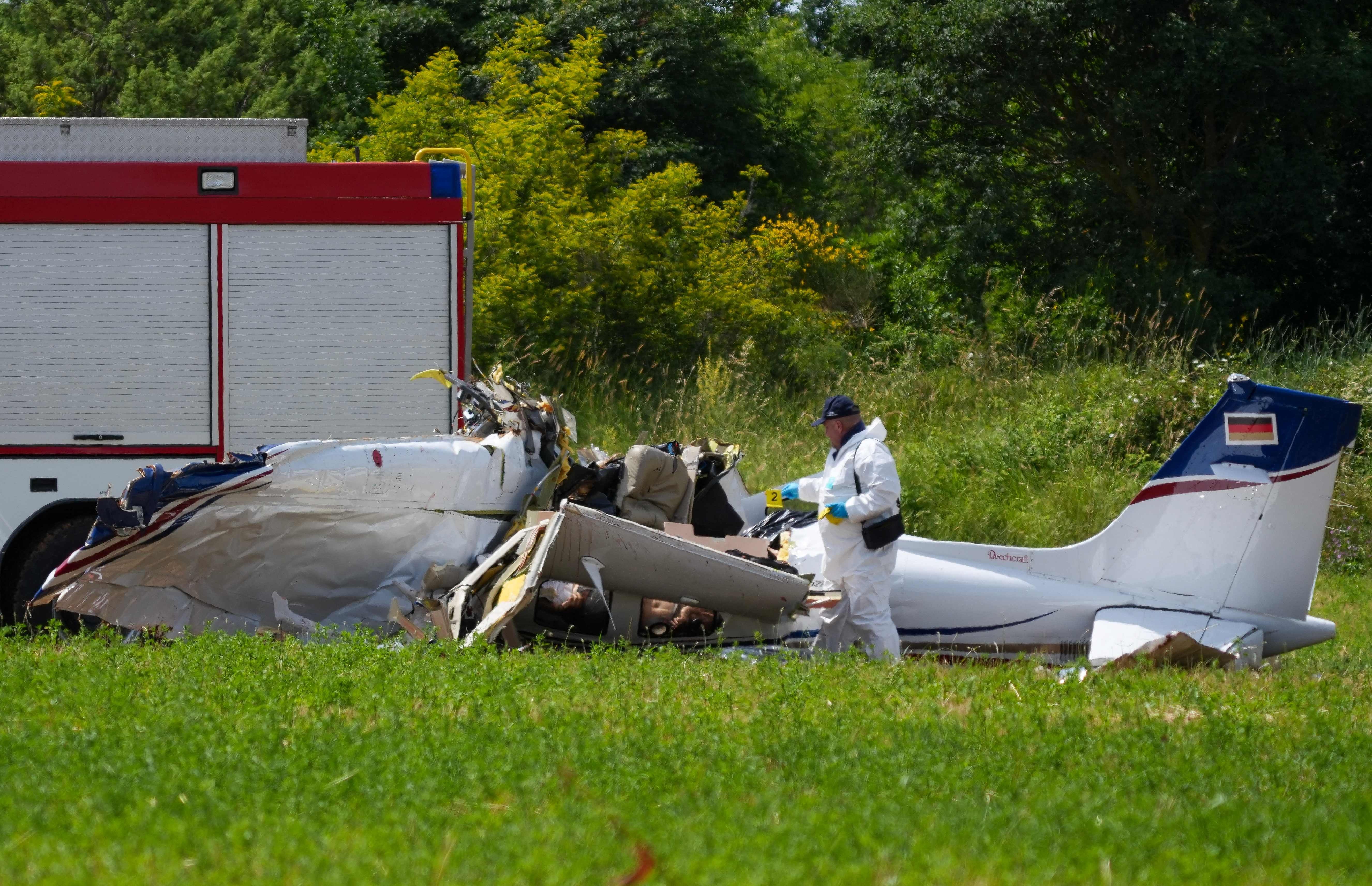 A police officer in protective gear collects evidences at site of a small plane crash, which killed 4 people, in Medulin on Croatia's northern Adriatic coast, on June 4, 2026. The accident occurred in the Campanoz area, outside the town, and 'all emergency services are on the scene'. According to the state-run HRT broadcaster, it was a small aircraft registered in Germany, which had taken off from Austria with Medulin as its destination. (Photo by AFP)