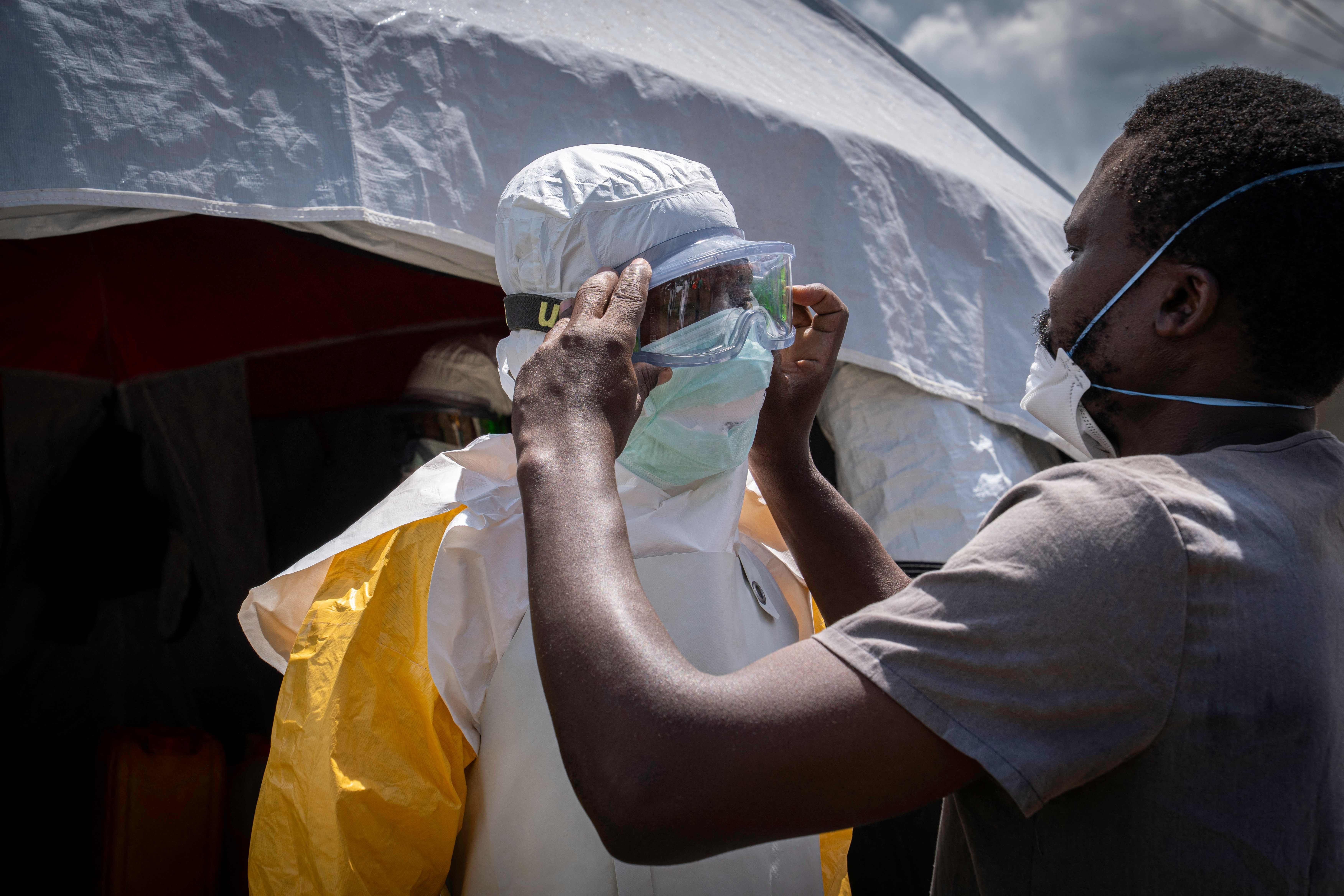 Doctors Without Border (MSF) personnel at the Elikya clinic Ebola treatment center is helped to wear the personal protection equipment (PPE) as he prepares to enter the hospital rooms for Ebola patients in Bunia, in the eastern Democratic Republic of the Congo, on June 5, 2026. (Photo by GLODY MURHABAZI / AFP)