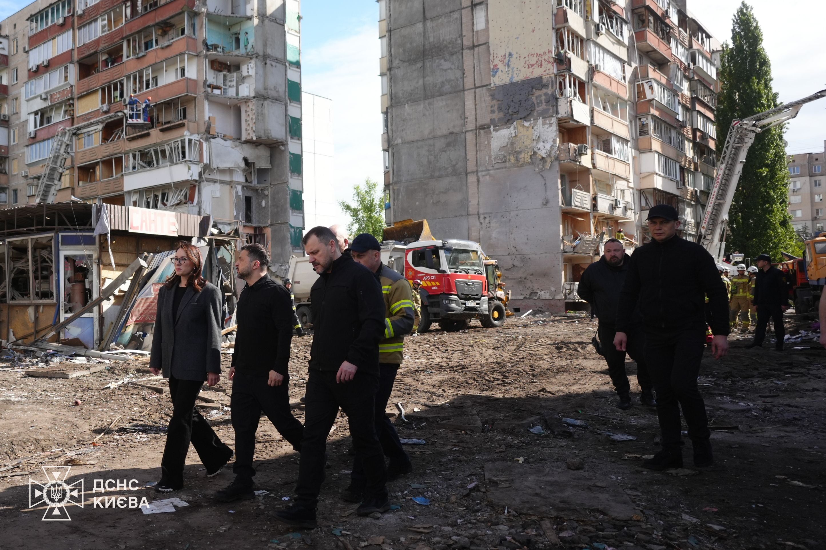 KYIV, UKRAINE - MAY 15: (----EDITORIAL USE ONLY - MANDATORY CREDIT - 'UKRAINIAN PRESIDENCY / HANDOUT' - NO MARKETING NO ADVERTISING CAMPAIGNS - DISTRIBUTED AS A SERVICE TO CLIENTS----) Ukrainian President Volodymyr Zelenskyy (L) pays tribute to the victims at the site of a nine-story residential building partially destroyed by a Russian missile strike in Kyiv, Ukraine on May 15, 2026. Following a search and rescue operation, officials confirmed that the death toll has risen to 24, including three children, while 48 others remain injured. (Photo by Ukrainian Presidency / Handout/Anadolu via Getty Images)
