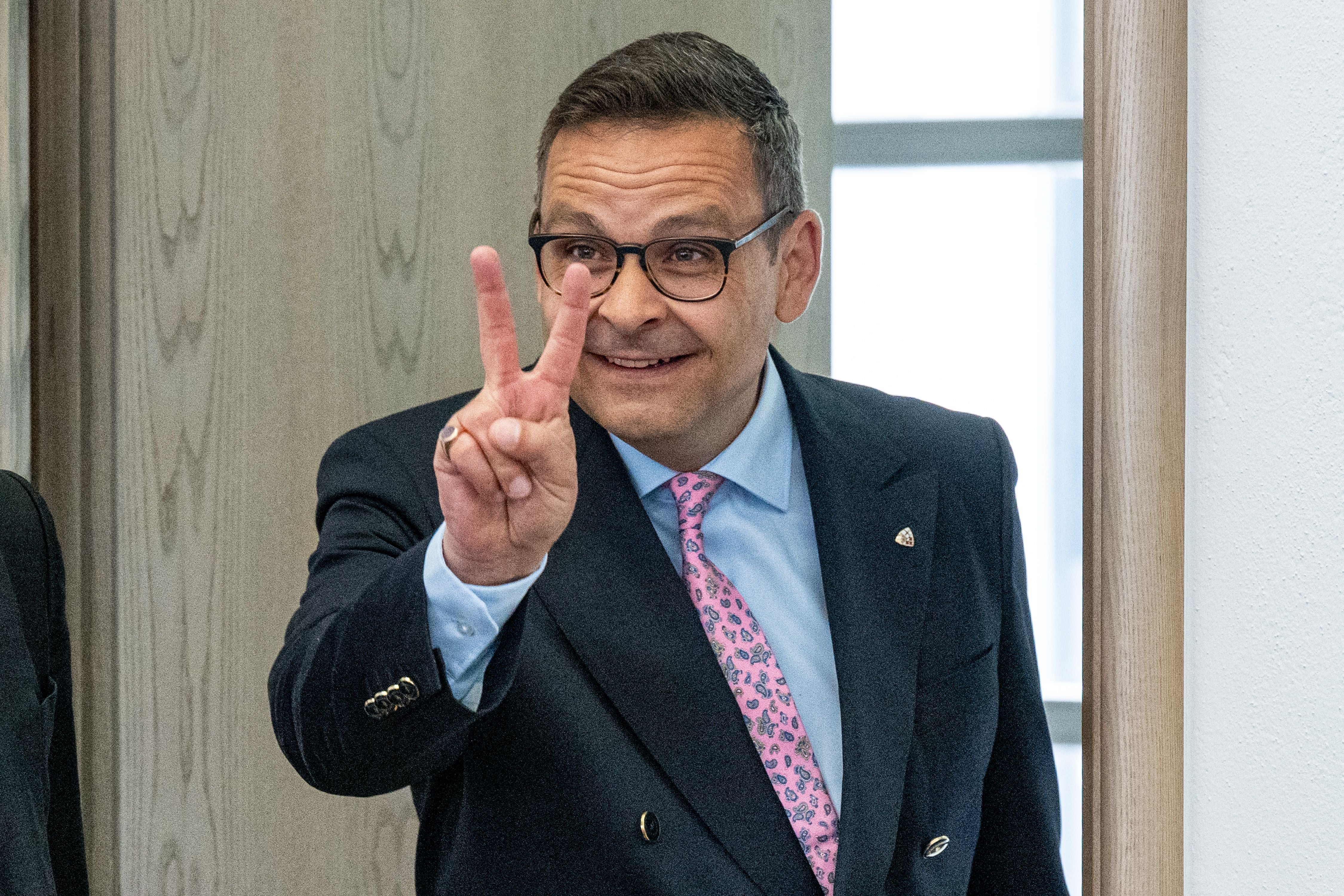 ABD0002_20240408 - DEGGENDORF - DEUTSCHLAND: 08.04.2024, Bayern, Deggendorf: Der österreichische Politiker Gerald Grosz macht im Verhandlungssaal des Amtsgerichts ein Victory-Zeichen. Der frühere österreichischer Politiker soll den bayerischen Ministerpräsidenten beleidigt haben. Einen Strafbefehl will der Mann nicht akzeptieren - nun steht er vor Gericht. Foto: Armin Weigel/dpa +++ dpa-Bildfunk +++. - FOTO: APA/dpa/Armin Weigel