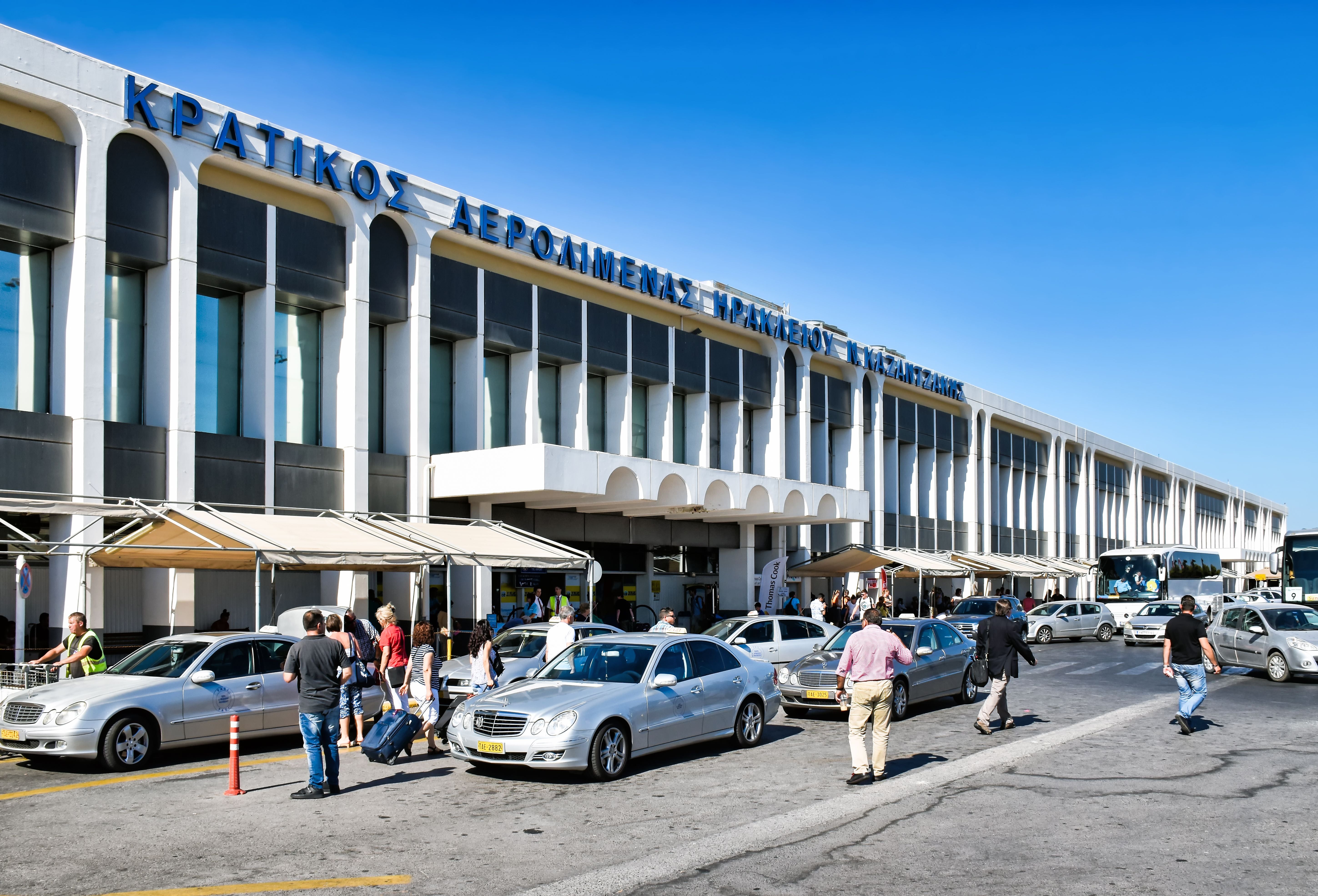 Heraklion, Greece - June 22, 2016: In front of the entrance of the Iraklio airport "Nikos Kazantzakis", the main airport of the Greek island Crete, numerous taxis and buses wait for guests.