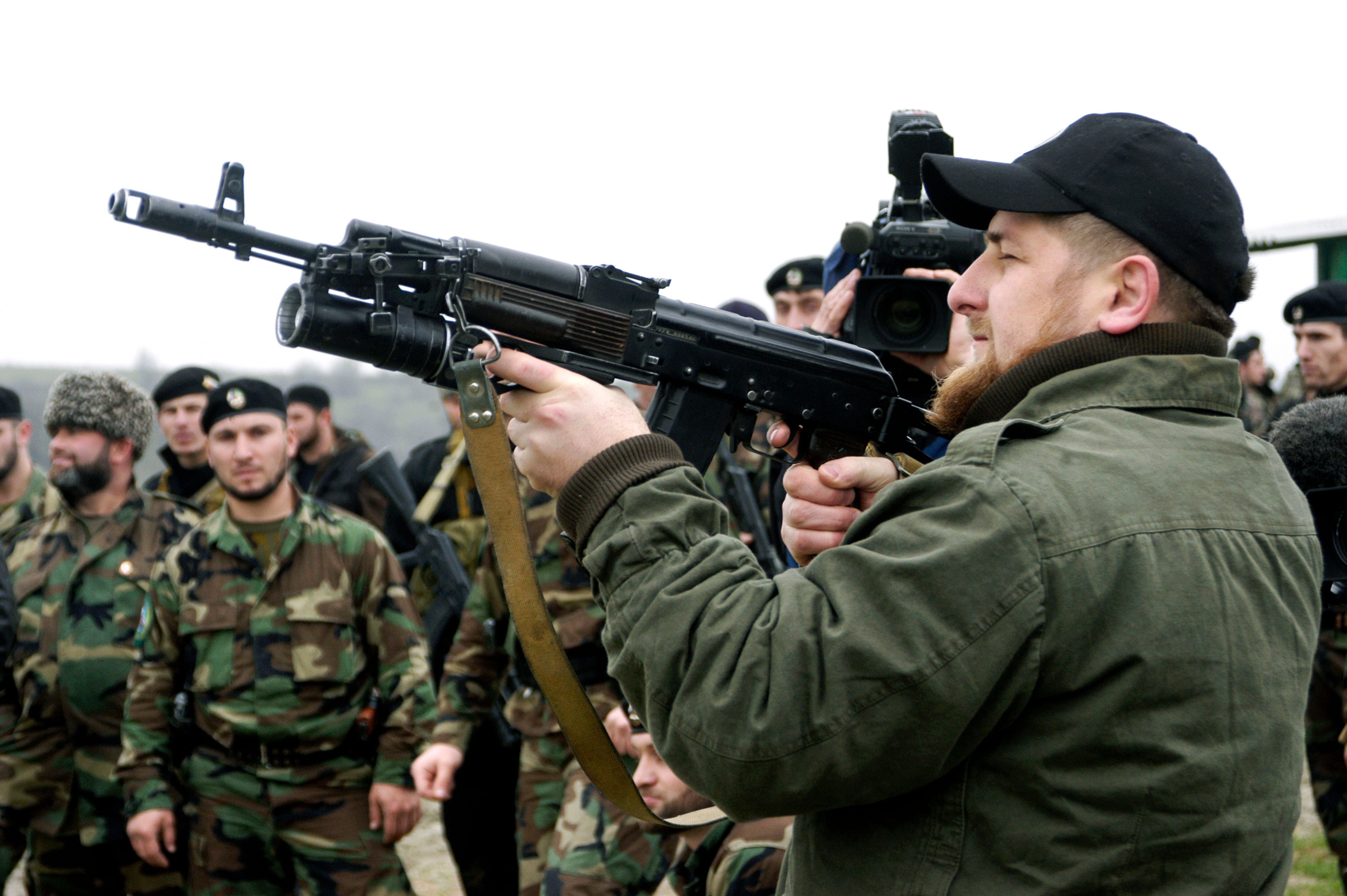 TSENTEROI, CHECHNYA, RUSSIA - NOVEMBER 2005: Ramzan Kadyrov proudly displays his shooting skills at a firing range in his village of Tsentoroi in front of members of his private army. Officially his army are known as the anti-terrorism squad, but everyone refers to its soldiers as Kadyrovtsy - "Kadyrov's guys". Ramzan was born 5 October 1976 in Tsenteroi, Chechnya, and was made Prime Minister of Chechnya in the beginning of March 2006 and leader of a powerful Chechen militia known as kadyrovtsy. He is the son of former Chechen President Akhmad Kadyrov, who was assassinated in May 2004. He has the backing of Russian President Vladimir Putin, and was awarded the Hero of Russia medal, the highest honorary title of the Russian Federation. As the head of the Chechen Presidential Security Service, Kadyrov has often been accused of being brutal, ruthless and antidemocratic; according to media and human rights groups, he was personally implicated in several instances of torture and murder. It is also rumoured that he owns a private prison in his stronghold village of Tsenteroi, where he uses inmates as a punching bags. Kadyrov is known for keeping a pet lion cub, given to him as a gift after the birth of his first son, as well as a tiger and a number of a fighting dogs, and also used to own a wolf and a bear. He has only a few classes of elementary education finished; despite his lack of education, Kadyrov is a honorary member of the Russian Academy of Sciences. (Photo by Kadyrov Press Office/Getty Images)