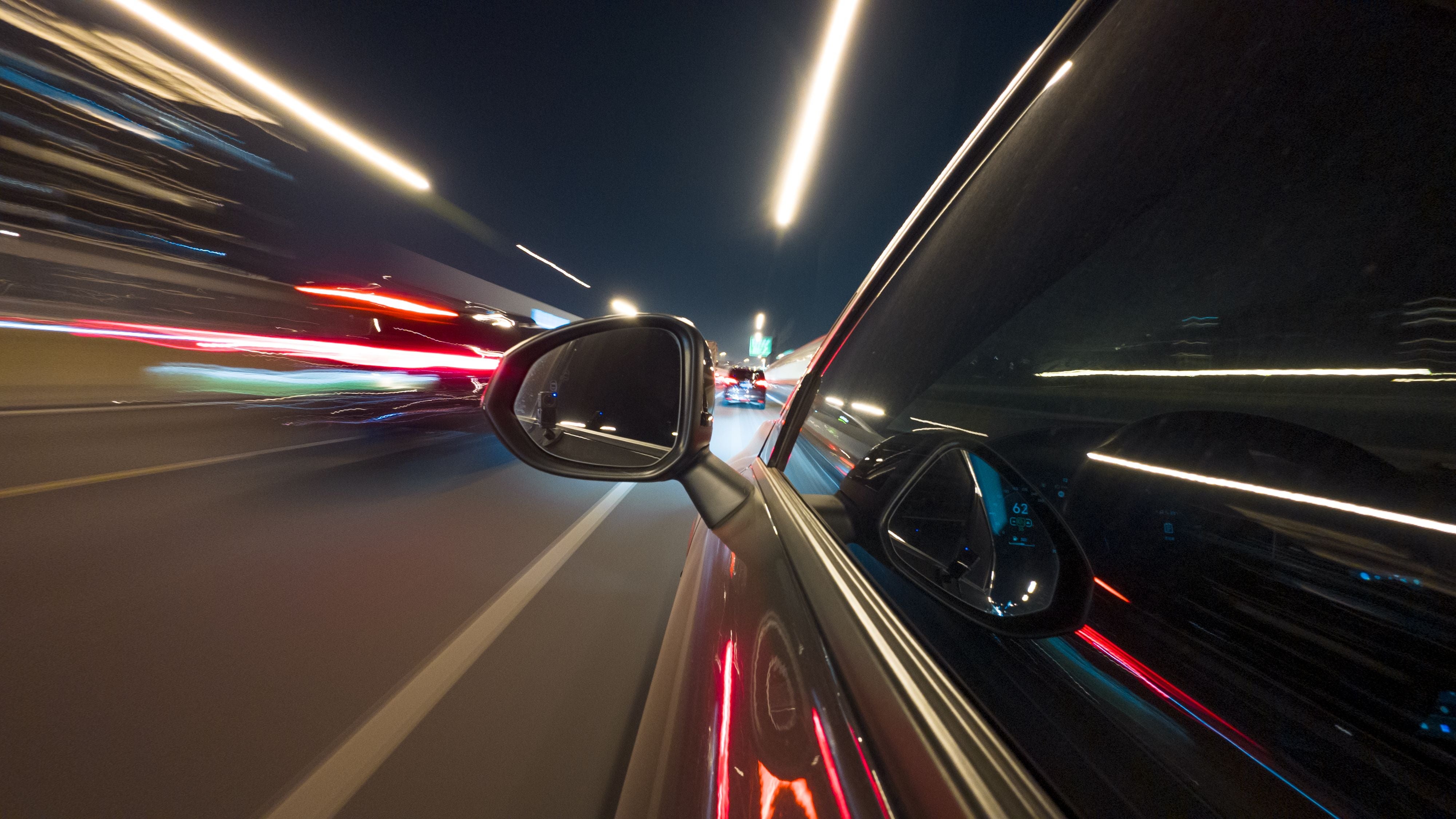 Speeding car in illuminated tunnel at night