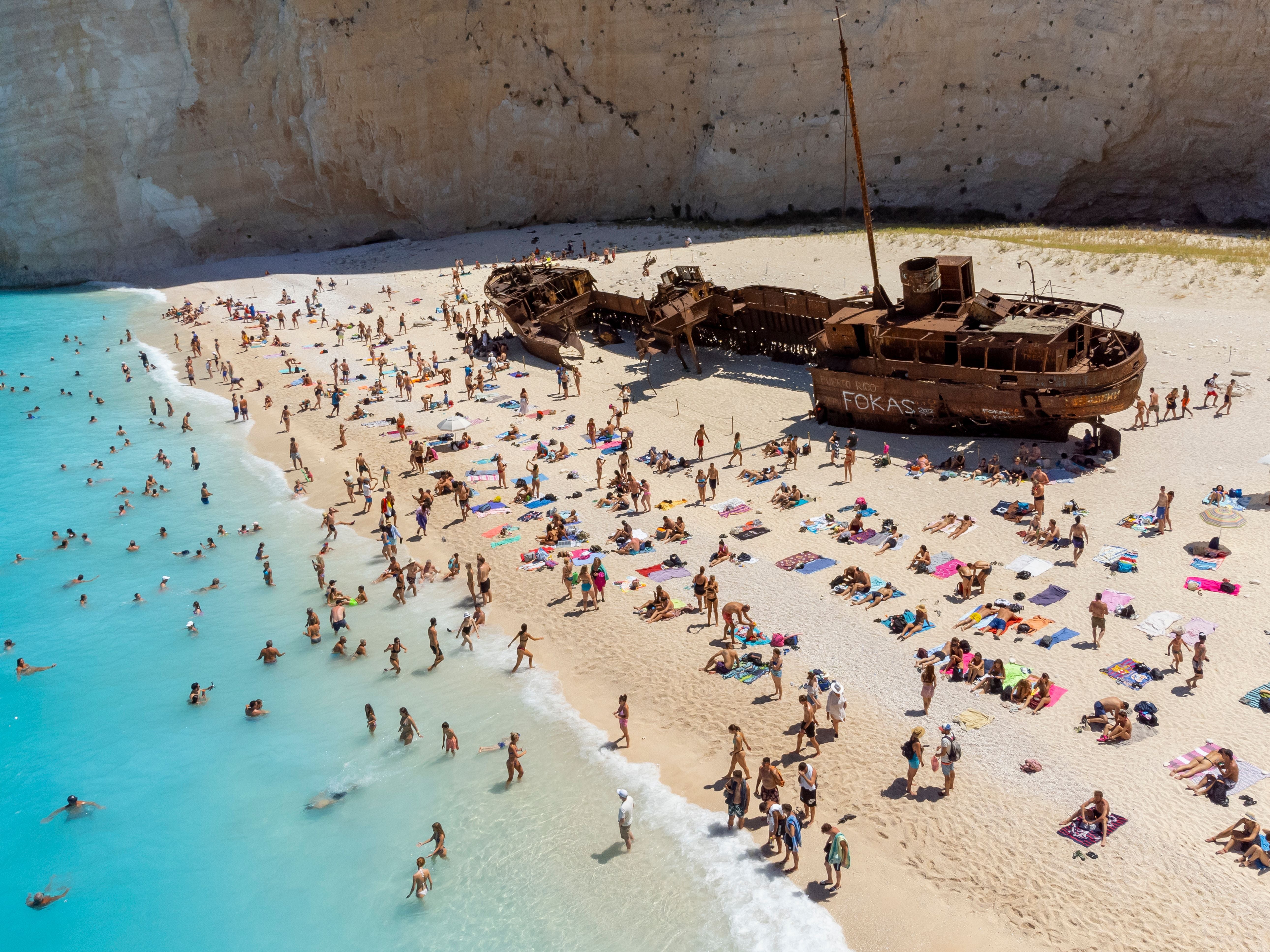 ZAKINTHOS, GREECE - AUGUST 09: Aerial view of Navagio Beach or Shipwreck Beach on August 09, 2022 in Zakinthos, Greece. On 2 October 1980, the ship ran aground in the waters during stormy weather and bad visibility. Some rumours claim the ship was smuggling contraband from Turkey with a freight of contraband cigarettes headed for Italy. The ship was abandoned and still rests buried in the limestone gravel of the beach named Shipwreck. In 2018, the beach was named as the world's best beach in a poll by journalists. (Photo by Athanasios Gioumpasis/Getty Images)
