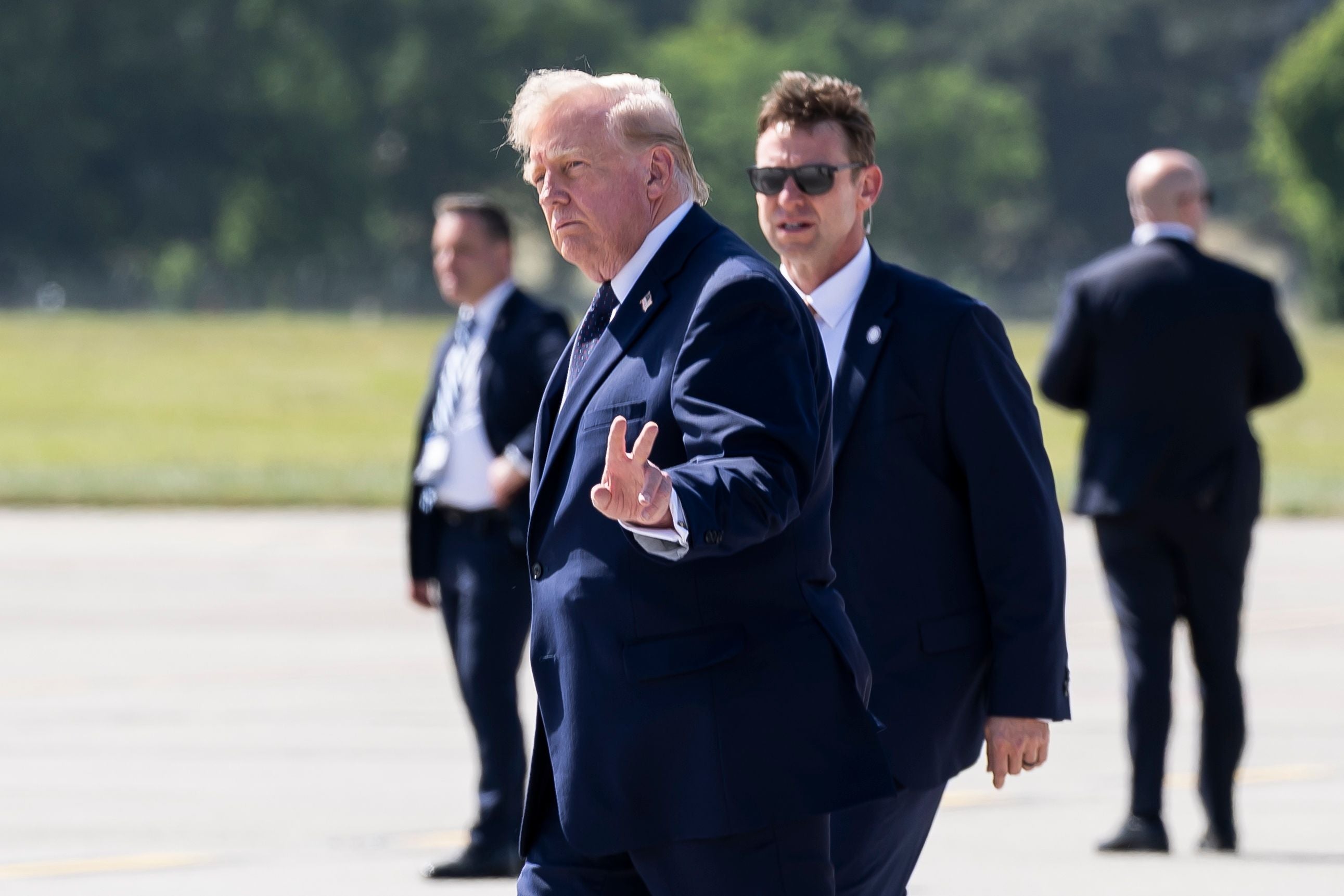 epaselect epa13039118 US President Donald J. Trump gestures after disembarking from Air Force One at Geneva Airport prior the G7 summit in Evian, in Geneva, Switzerland, 15 June 2026. The summit is scheduled to take place from 15 to 17 June in nearby Evian, France. EPA/MARTIAL TREZZINI / POOL