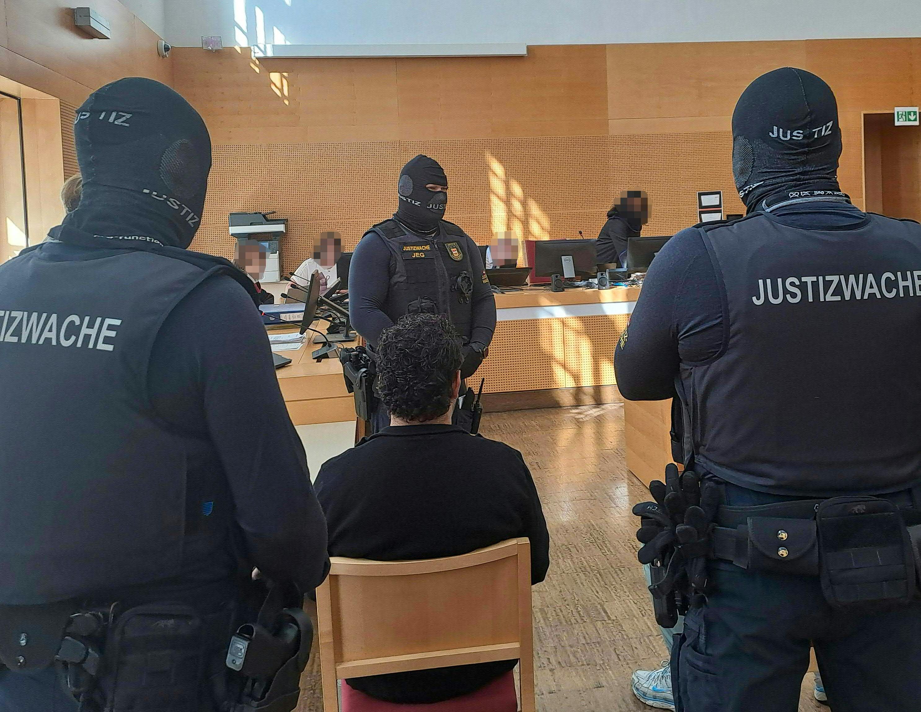 Die gut bewachten Angeklagten vor Gericht.
