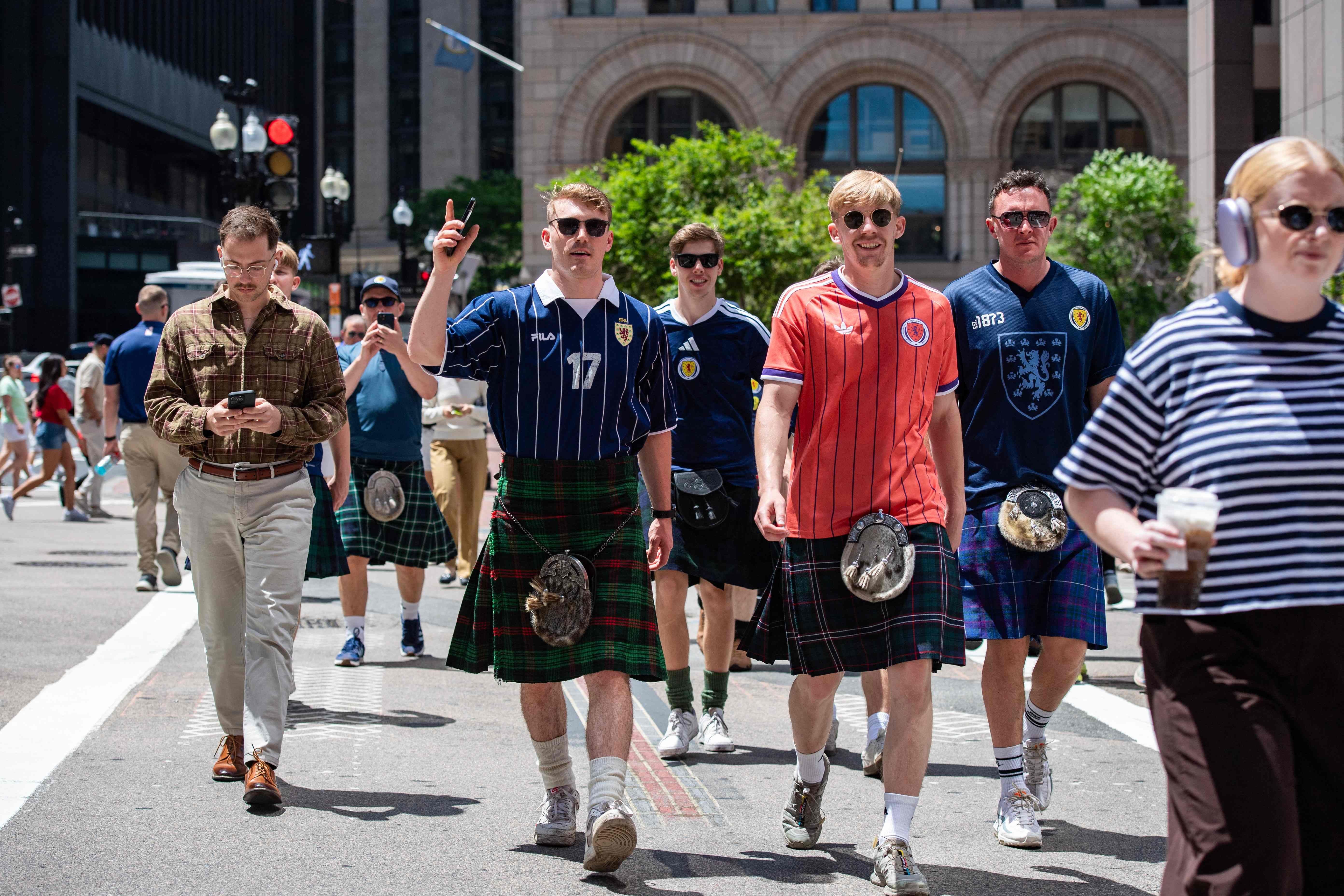 Scottish tourist, members of the Tartan Army, walk around Boston, Massachusetts, on June 17, 2026, ahead of the 2026 World Cup football match between Scotland and Morocco. From drinking the bars dry to lustily serenading an iconic baseball stadium with a rendition of 'Flower of Scotland', the bagpipe-playing, kilt-wearing hordes of the Tartan Army have captivated Boston since arriving at the World Cup. Scotland's famously good-natured travelling supporters had waited nearly 30 years for the chance to follow their team to a World Cup and the thousands who have made the journey to the tournament are merrily making up for lost time, to the delight of Bostonians. (Photo by Joseph Prezioso / AFP)