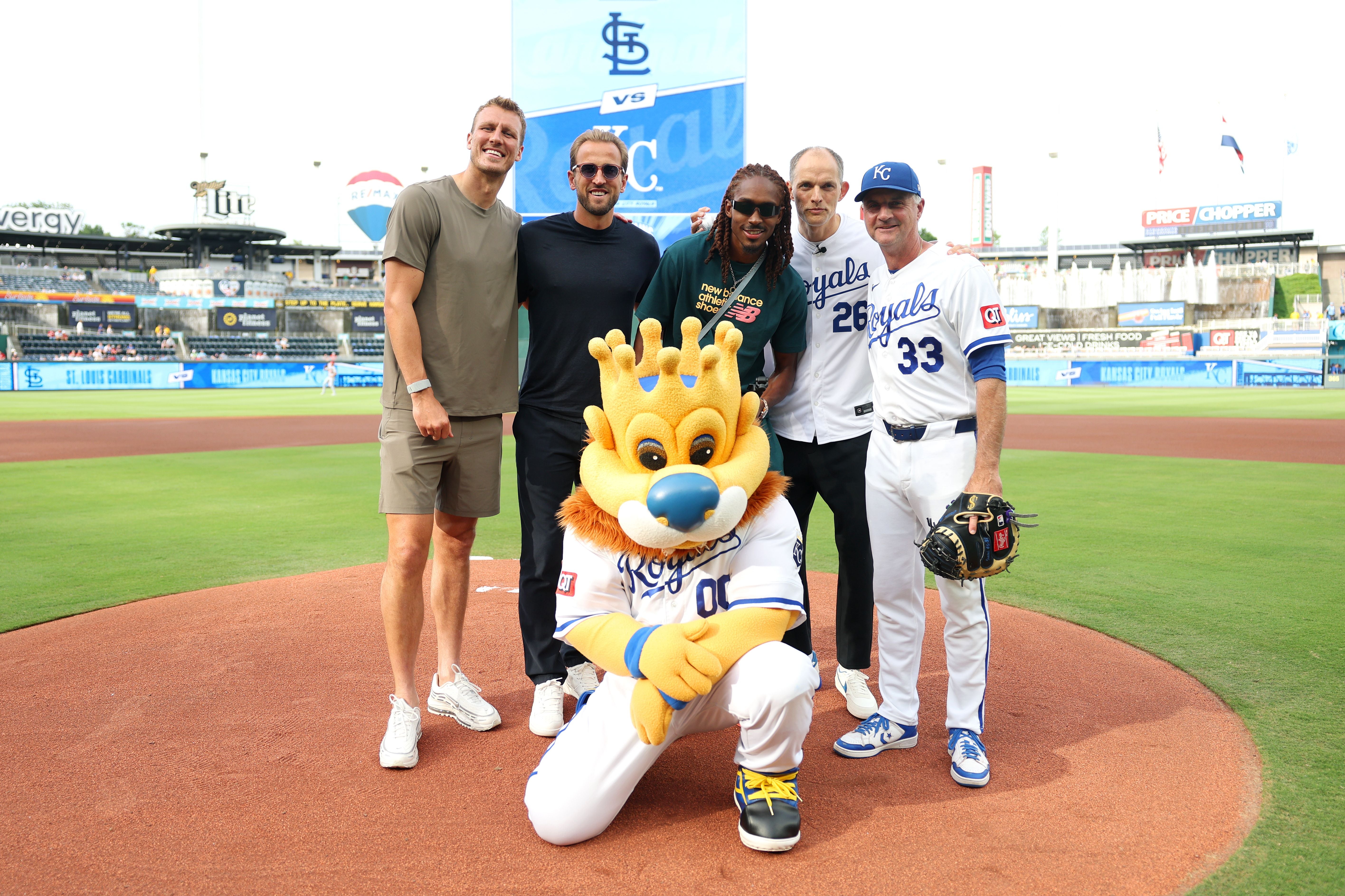 KANSAS CITY, KANSAS - JUNE 18: Dan Burn, Djed Spence, Harry Kane and Thomas Tuchel, Manager of England, pose for a photograph alongside Mascot Sluggerrr and Matt Quatraro, Manager of Kansas City Royals as the England Team attend the Major League Baseball fixture between Kansas City Royals and St Louis Cardinals at Kauffman Stadium during the England FIFA World Cup 2026 Training Camp on June 18, 2026 in Kansas City, Kansas. (Photo by Eddie Keogh - The FA/The FA via Getty Images)