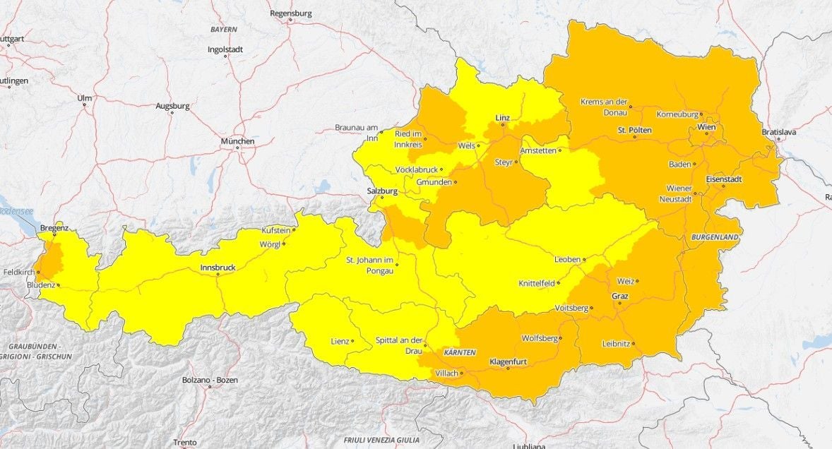 Karte von Österreich mit Regionen in Gelb und Orange, die Hitzebelastung anzeigen.