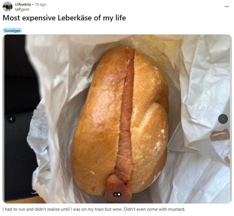 Ein einfaches Leberkässemmerl liegt in weißem Papier eingewickelt.