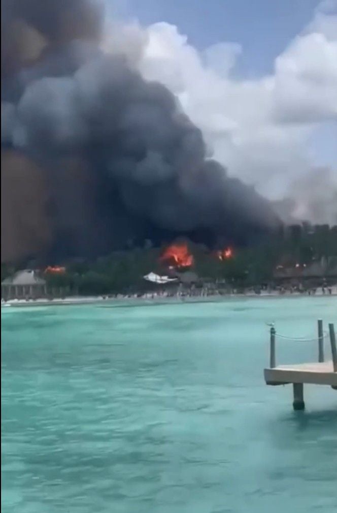 Dichter Rauch und Flammen steigen am Strand eines Hotels in der Dominikanischen Republik auf.