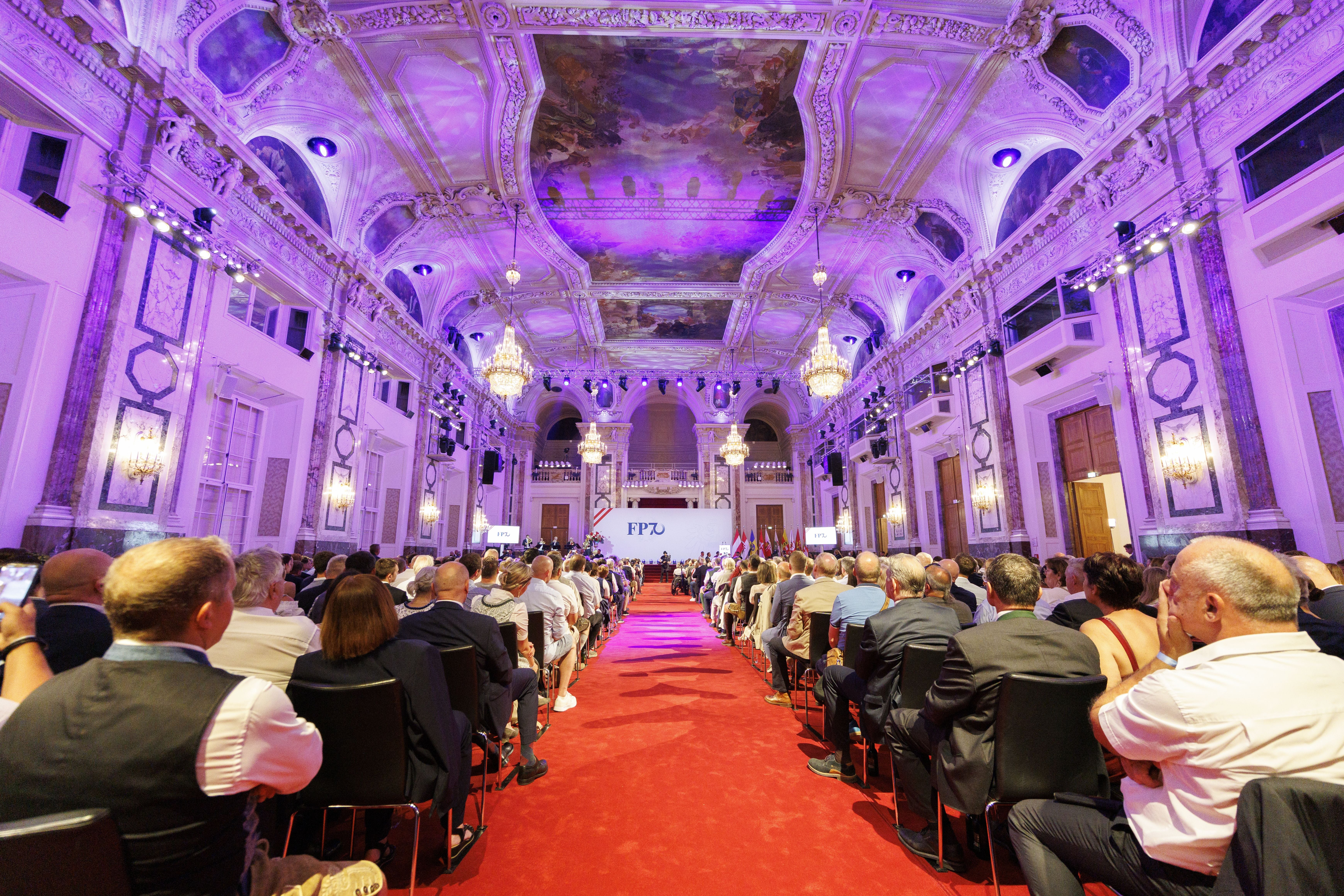 Festakt in prunkvollem Saal der Hofburg mit vielen Gästen und rotem Teppich, Bühne vorne.