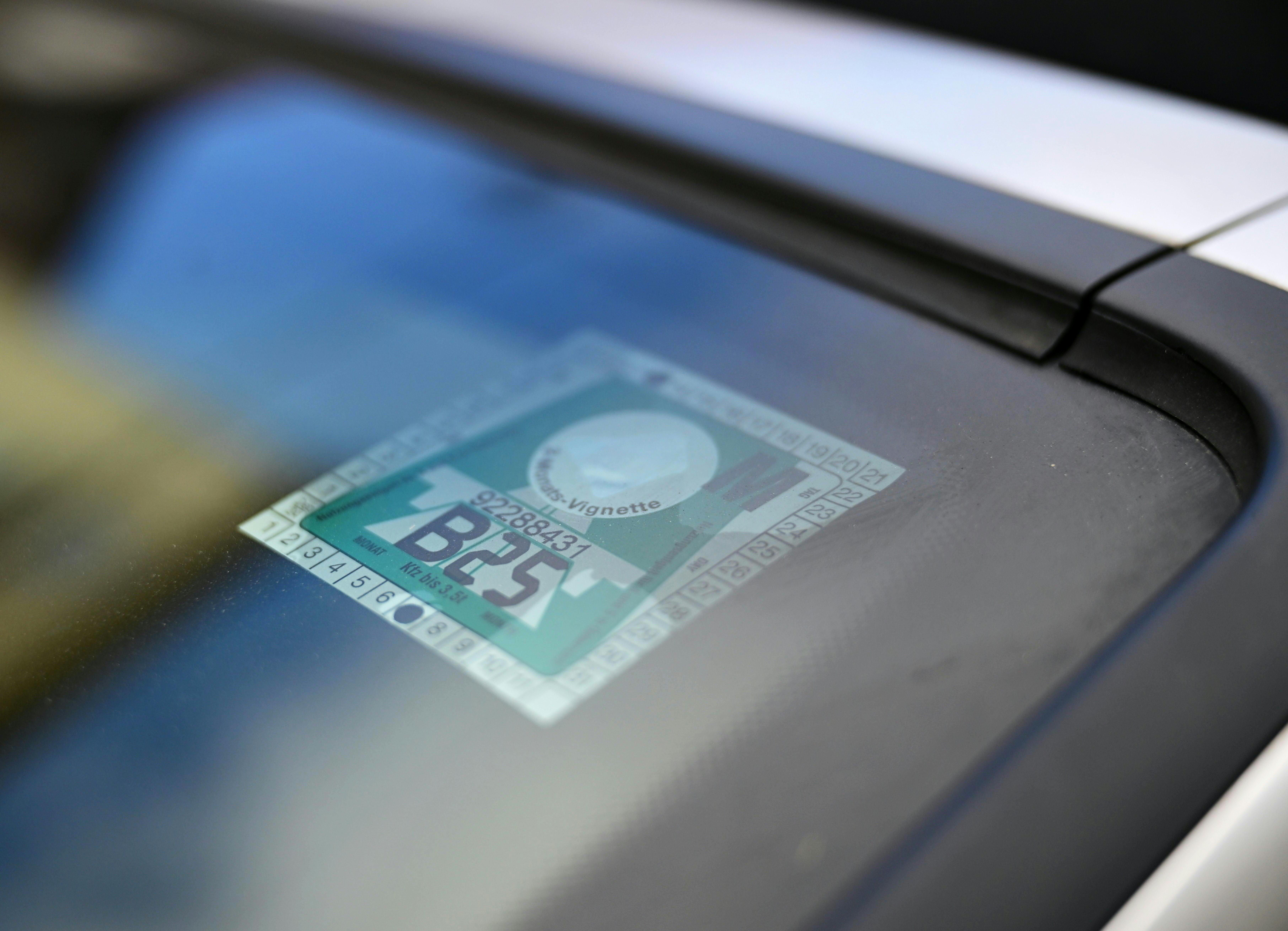 Eine Klebevignette ist an der Windschutzscheibe eines Autos angebracht.