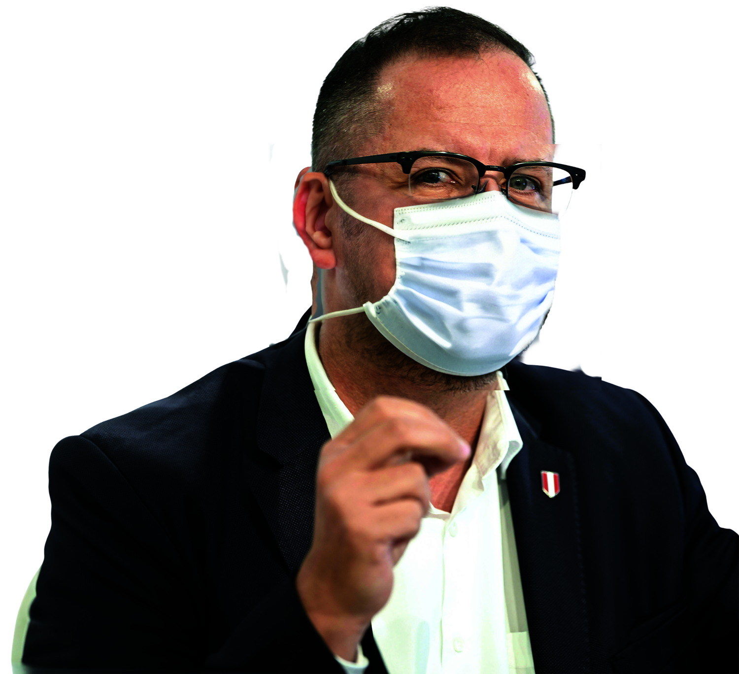 Ein Mann im Anzug spricht auf einer Pressekonferenz und trägt eine Mund-Nasen-Maske.