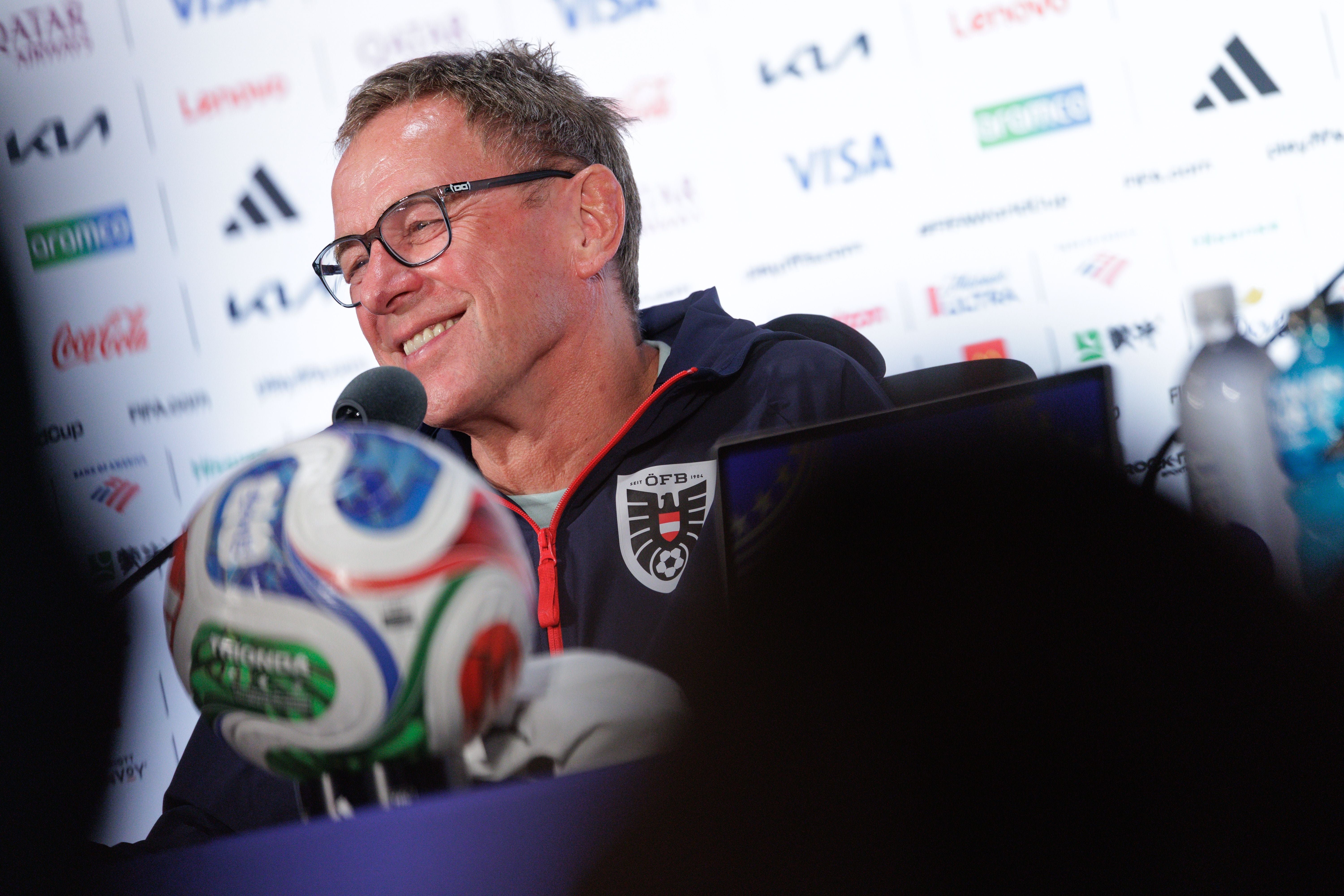 Ein Mann im ÖFB-Trainingsanzug sitzt bei einer Pressekonferenz, ein Fußball im Vordergrund.