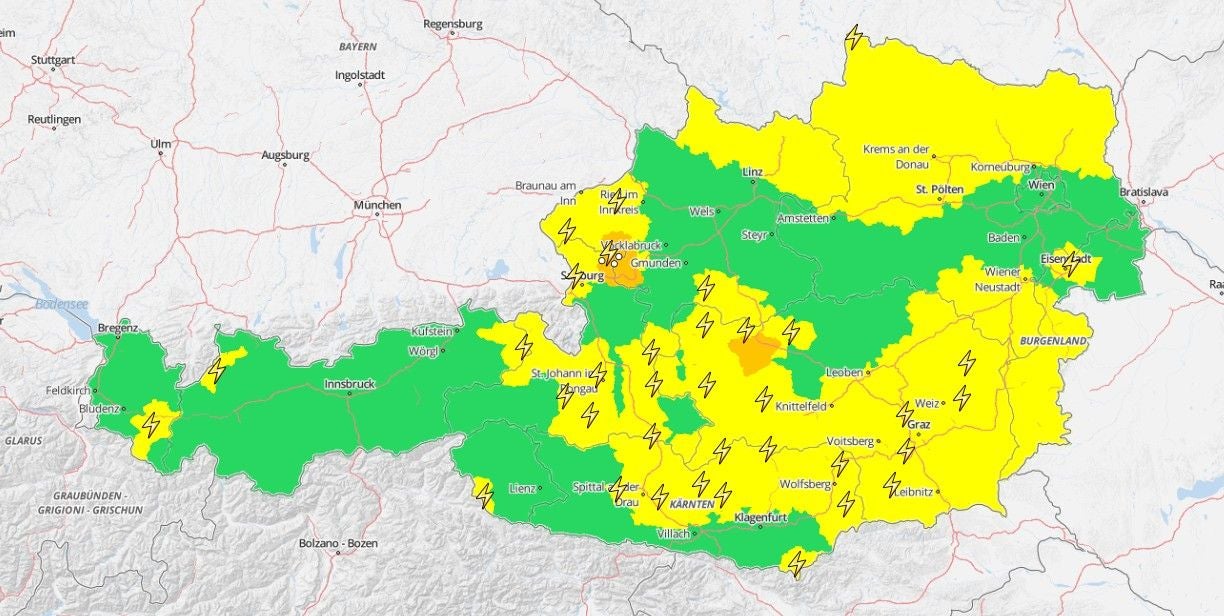 Unwetterkarte von Österreich mit gelben und orangen Warnstufen und Gewitter-Symbolen.