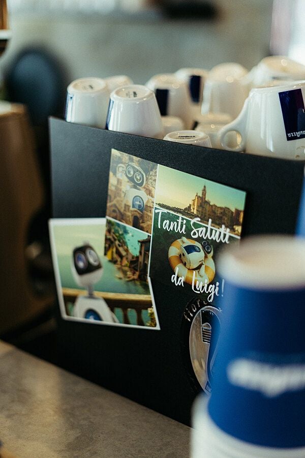 Mehrere Lavazza-Kaffeetassen stehen neben Grußkarten auf einem Tresen.