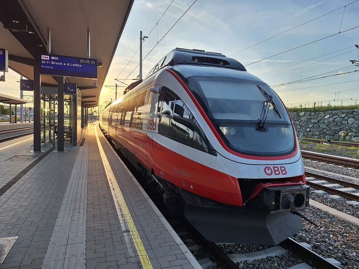 ÖBB-Zug steht bei Sonnenuntergang am Bahnsteig auf der Ostbahn.
