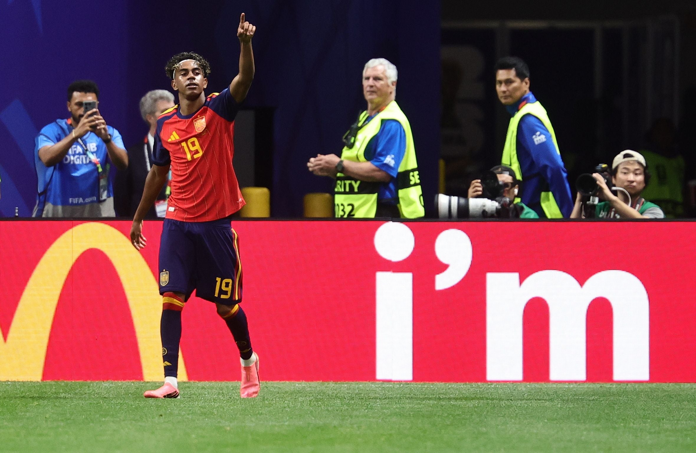 Ein spanischer Fußballspieler jubelt nach einem Tor, im Hintergrund Fotografen und Sicherheitskräfte.