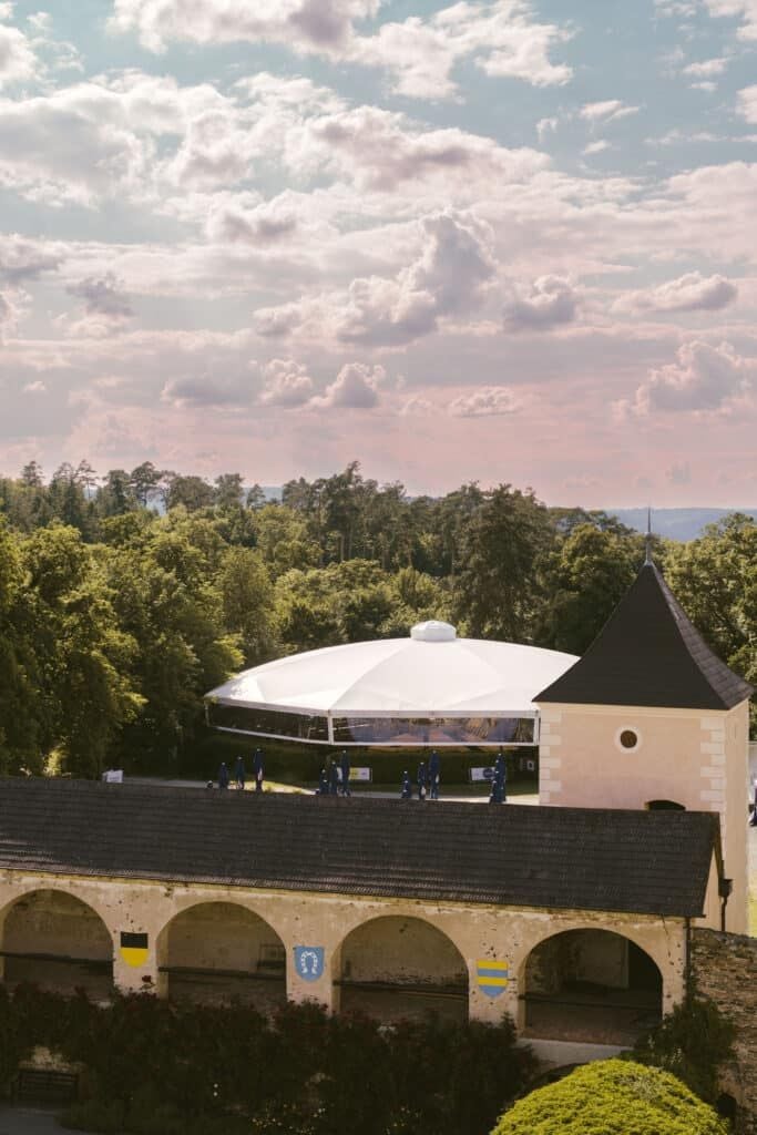Blick auf die Rosenburg mit Zinnen, Turm und Sommernachtskomödie-Zelt im Hintergrund.